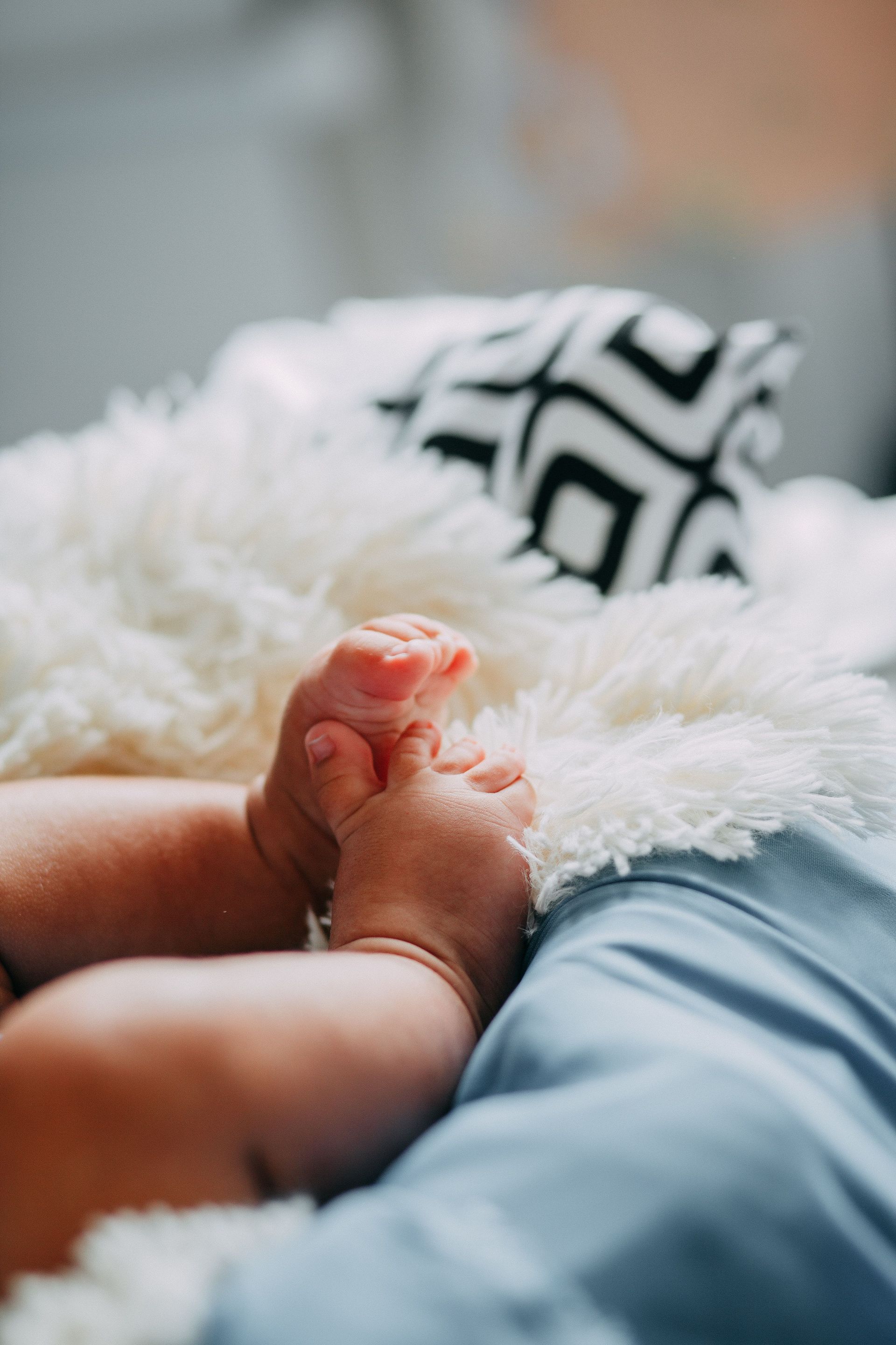 Close-up of adorable baby feet on a fluffy white blanket indoors. Warm and cozy atmosphere.